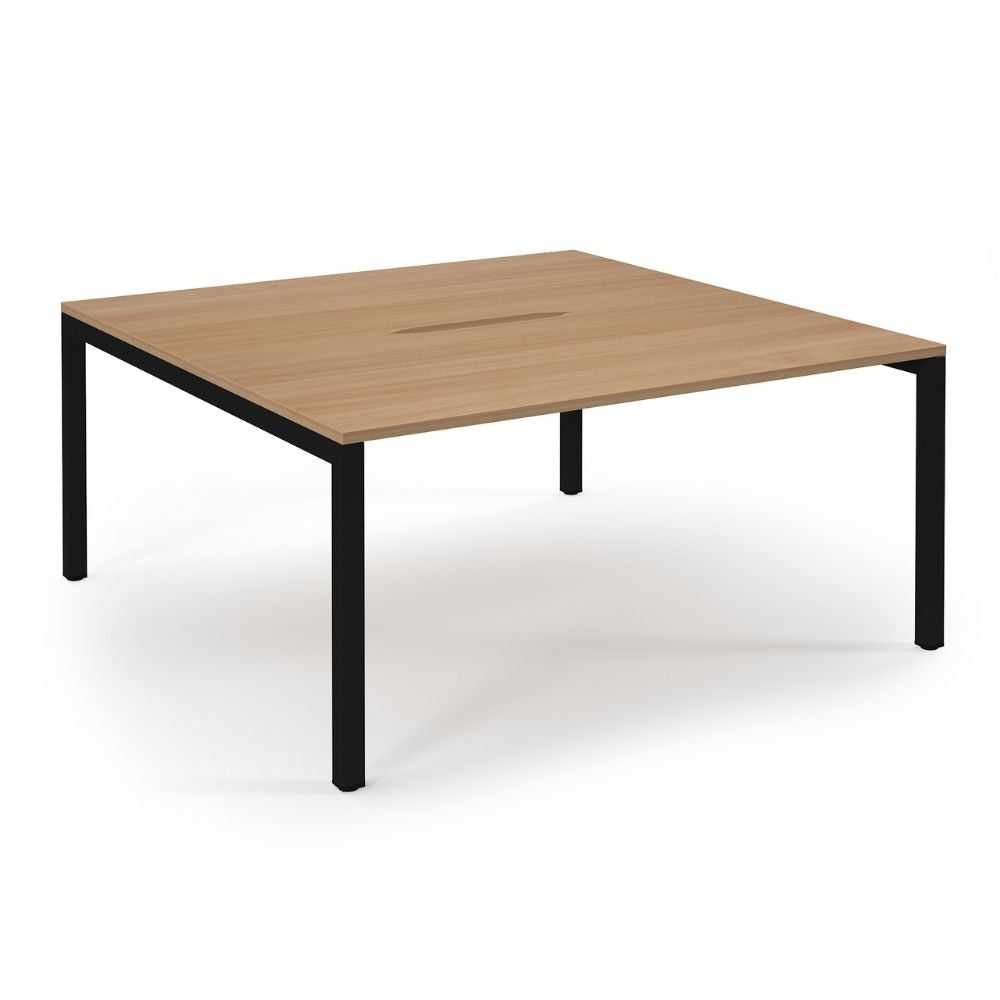 Square 4-person bench desk with a 1600mm x 1600mm wood-finish top and black metal frame, featuring a central cable management cut-out, ideal for shared office workstations.