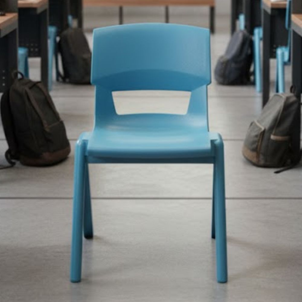 An aqua blue plastic chair in a secondary school classroom, aligned with rows of desks and student backpacks on a tiled floor for structured learning.