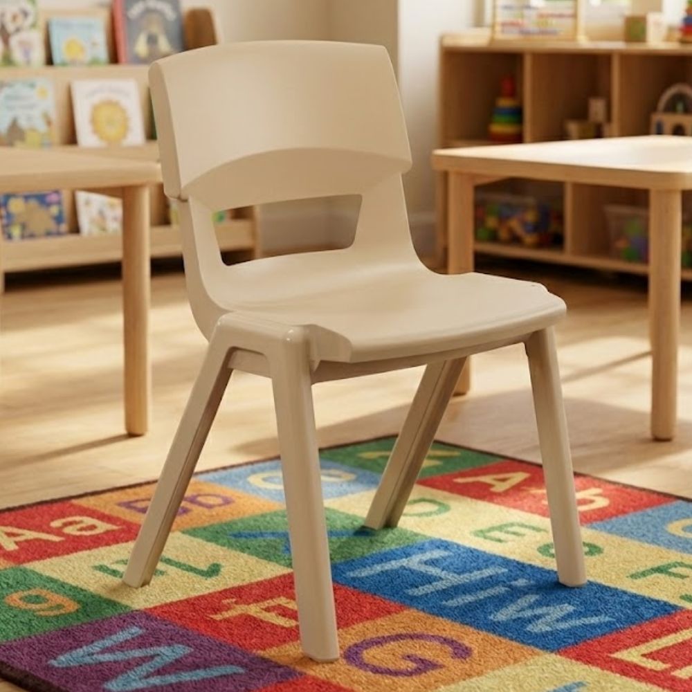 
Beige plastic chair for nursery or daycare, placed on multicoloured alphabet rug near bookshelves

