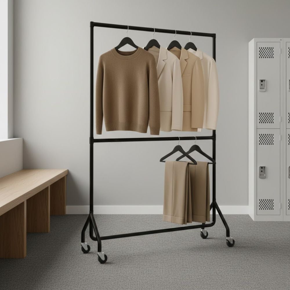 Black 5ft two-tier mobile clothes rail displaying neutral-toned knitwear, jackets and folded trousers on hangers in a modern workplace or changing area.