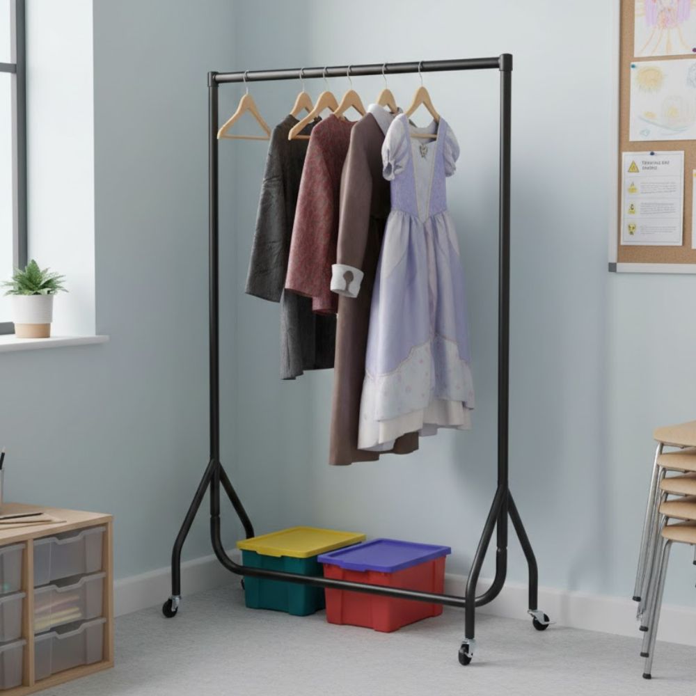 Black metal mobile clothes rail with children’s and adult garments hanging on wooden hangers in a classroom setting, with storage boxes beneath.