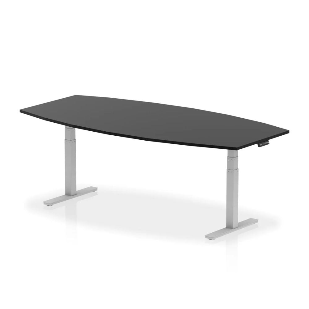 Modern black organic shaped sit stand desk with white electric height adjustable base and rectangular steel legs in a minimalist studio setting.