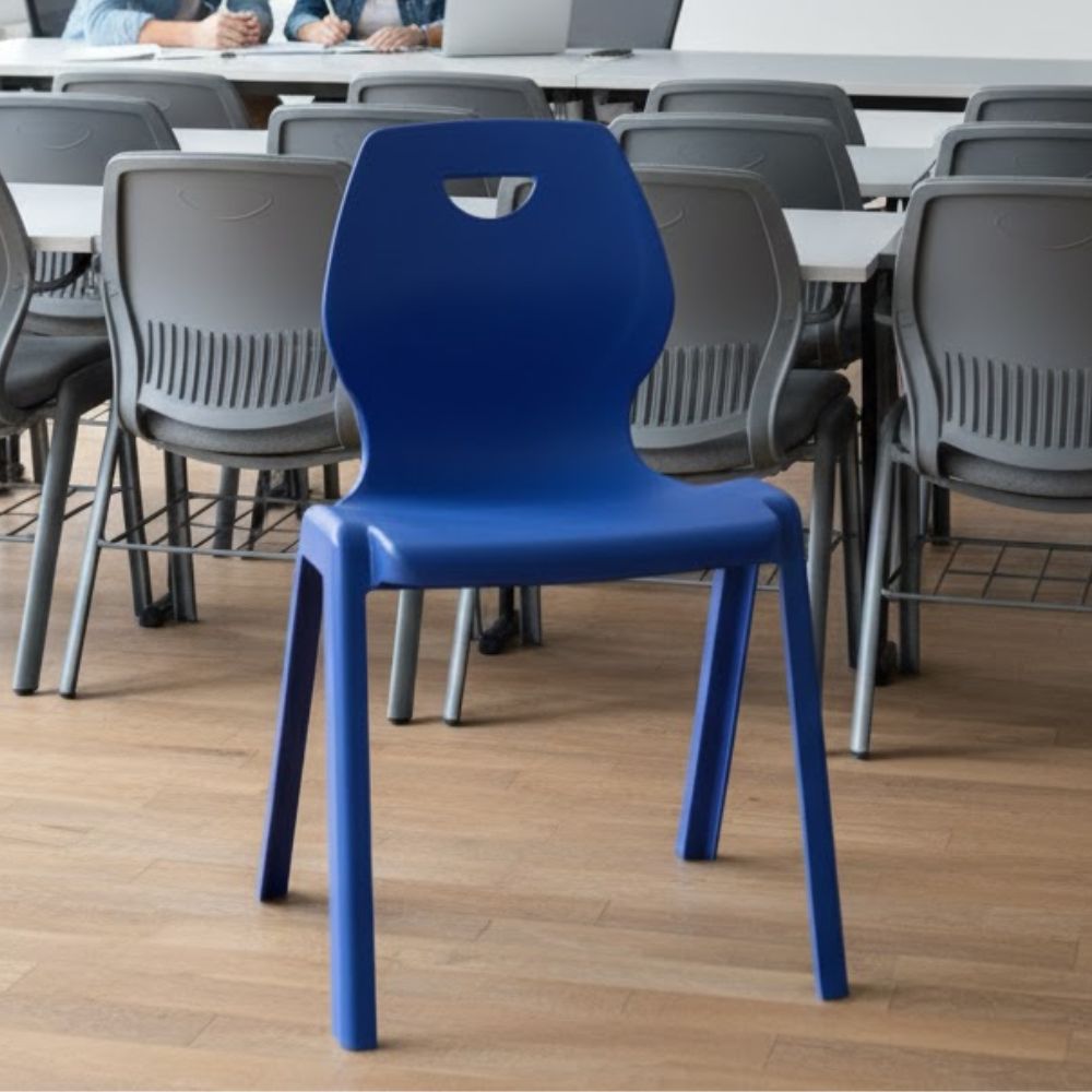 Blue plastic chair with modern silhouette and top handle, contrasting against standard grey seating.