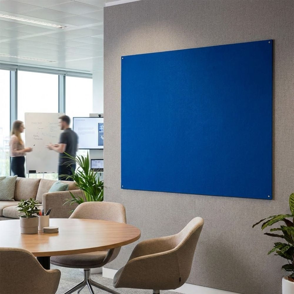 Blue unframed fire resistant felt noticeboard measuring 1500mm x 1200mm, wall mounted in a modern office meeting area with secure corner fixings.