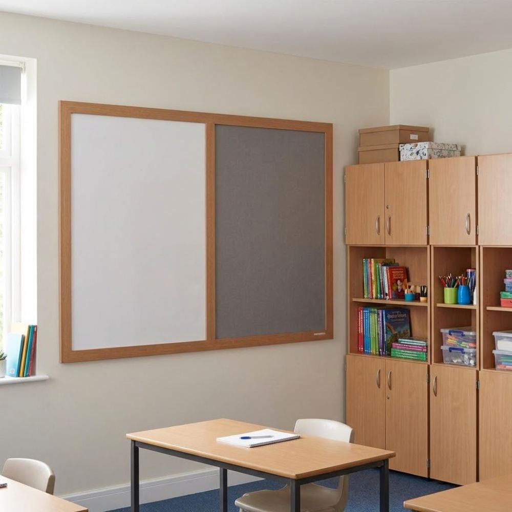 Eco-friendly combination board with grey felt panel and whiteboard surface in a wooden frame, mounted on a classroom wall beside storage cupboards and desks.