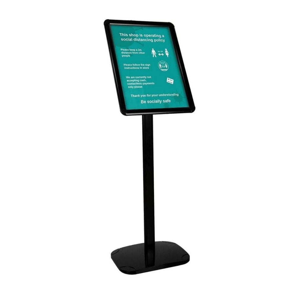 Freestanding sign holder with green background and white text outlining shop distancing policy and contactless payment instructions.
