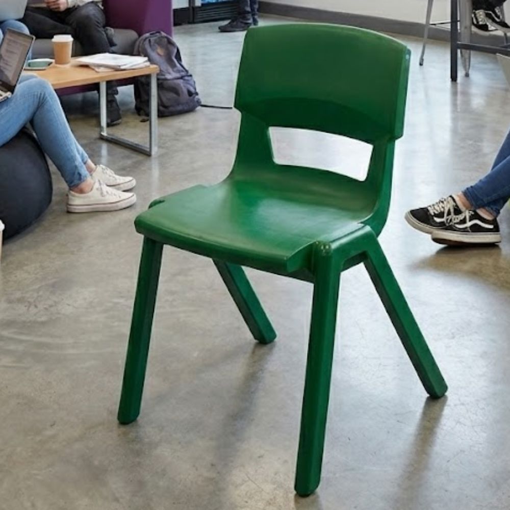 
Green plastic chair in a relaxed student lounge with bean bags, coffee cup, and laptop
