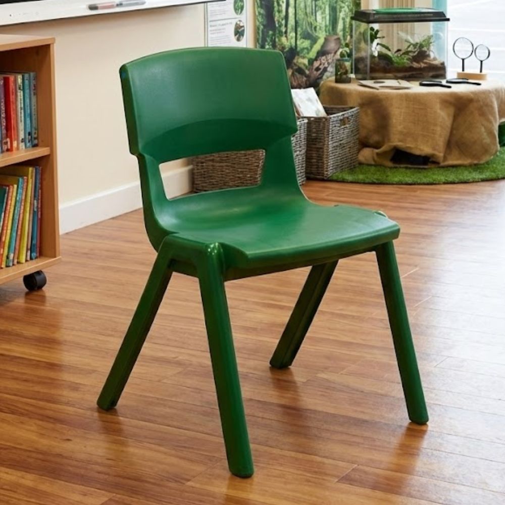 
Green plastic chair in a nature-themed classroom with terrarium, magnifiers, and forest backdrop
