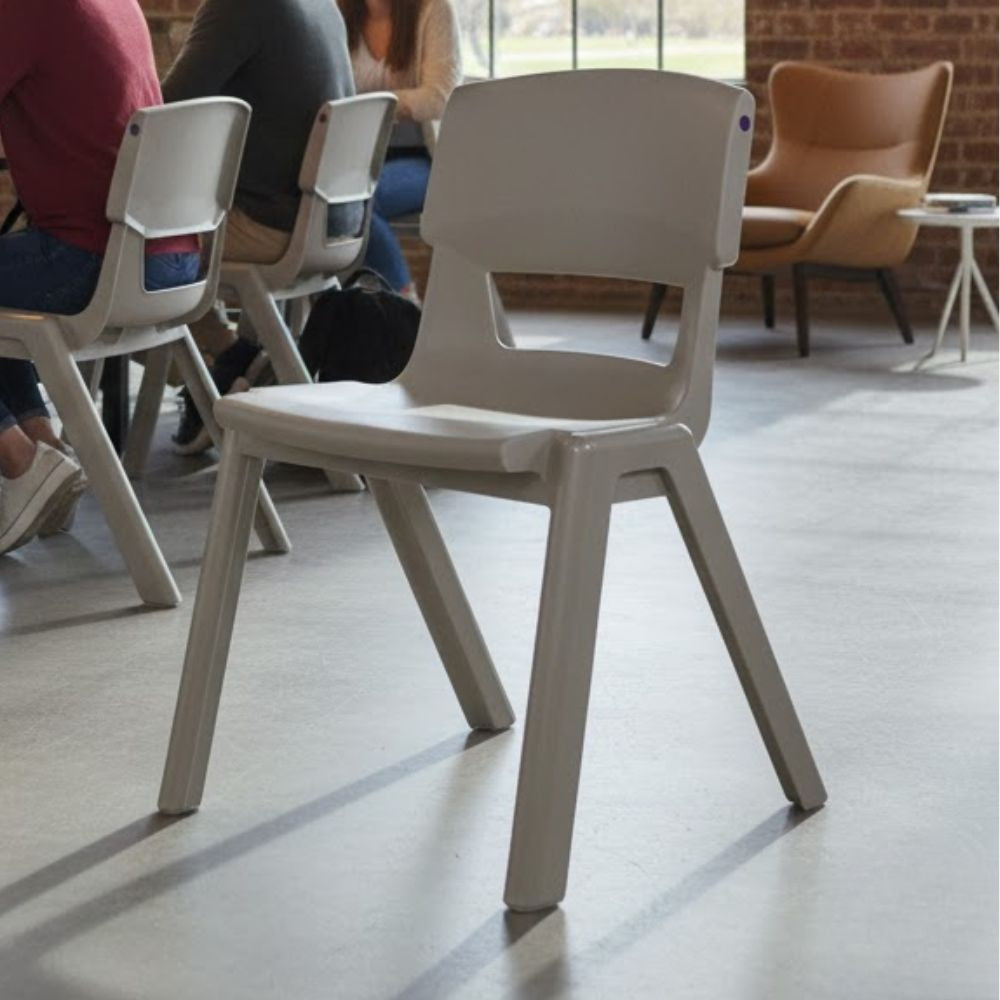 Light grey plastic chair in a modern meeting space with exposed brick walls and natural light

