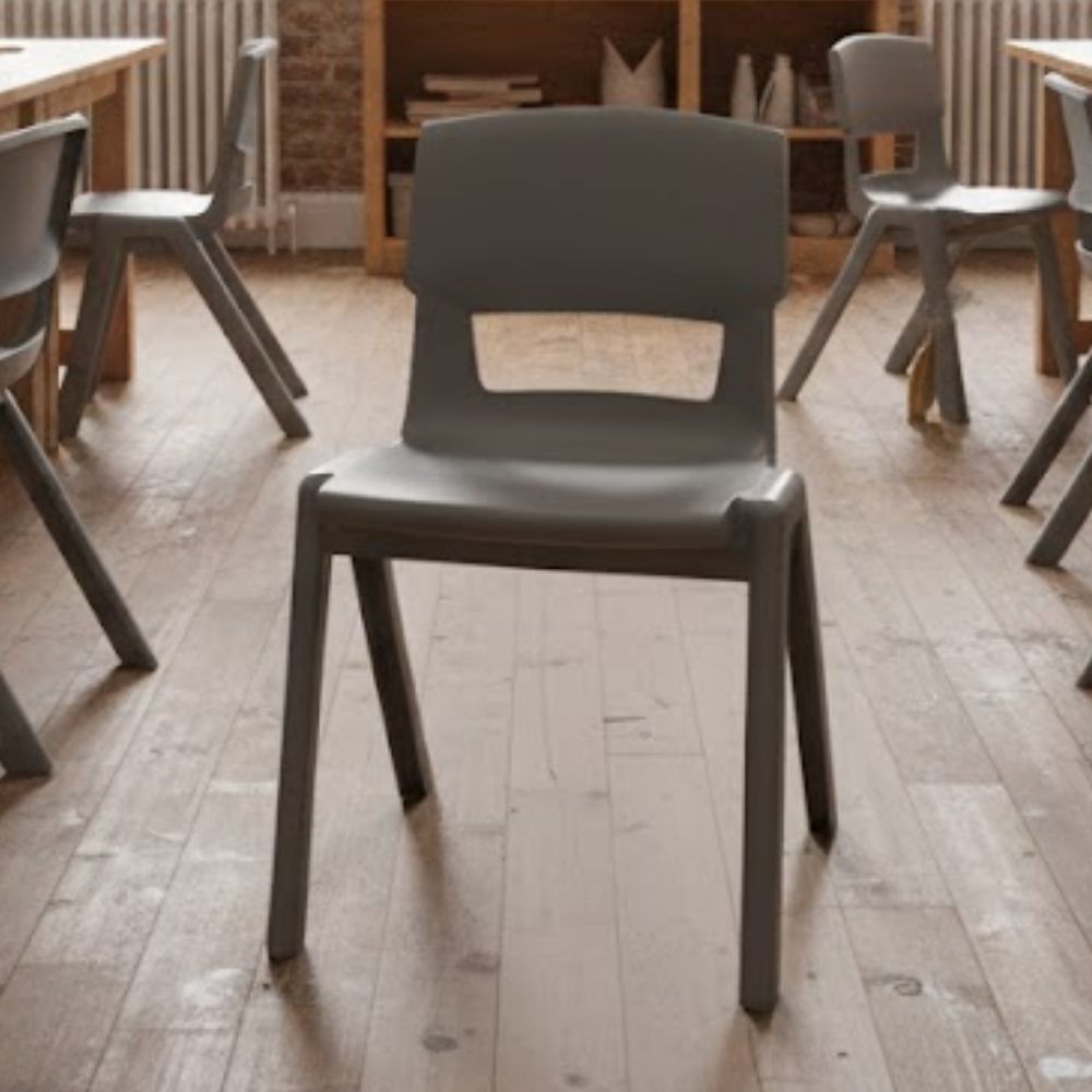 A mid-grey classroom chair in a rustic-style classroom with light wood flooring and shelving, creating a warm, nature-inspired learning space.