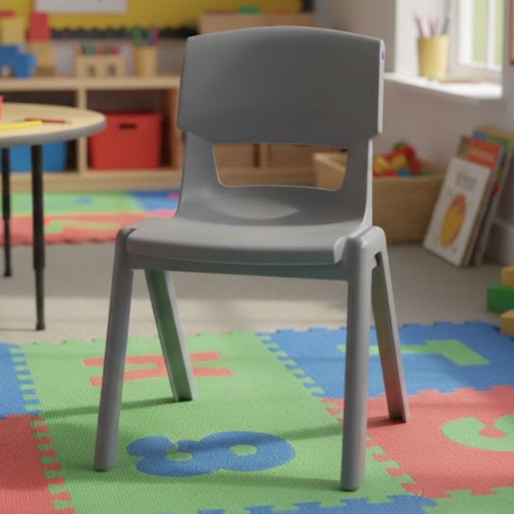 A mid-grey early years chair placed on a green and red number mat in a vibrant nursery setting, surrounded by playful learning resources and low tables.