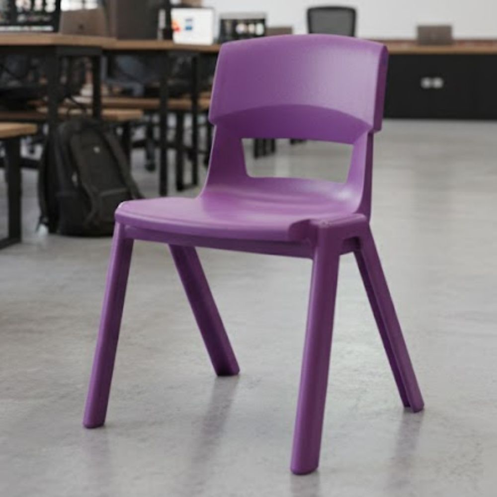 A purple plastic chair positioned in a modern ICT classroom or computer lab, with polished concrete floors and black workstations in the background.
