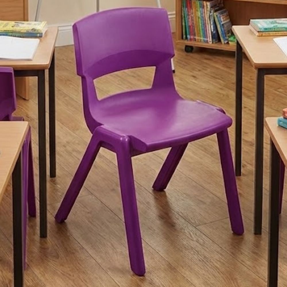 A purple school chair set on wood-effect flooring, arranged between traditional desks in a colourful primary learning environment with books and supplies.