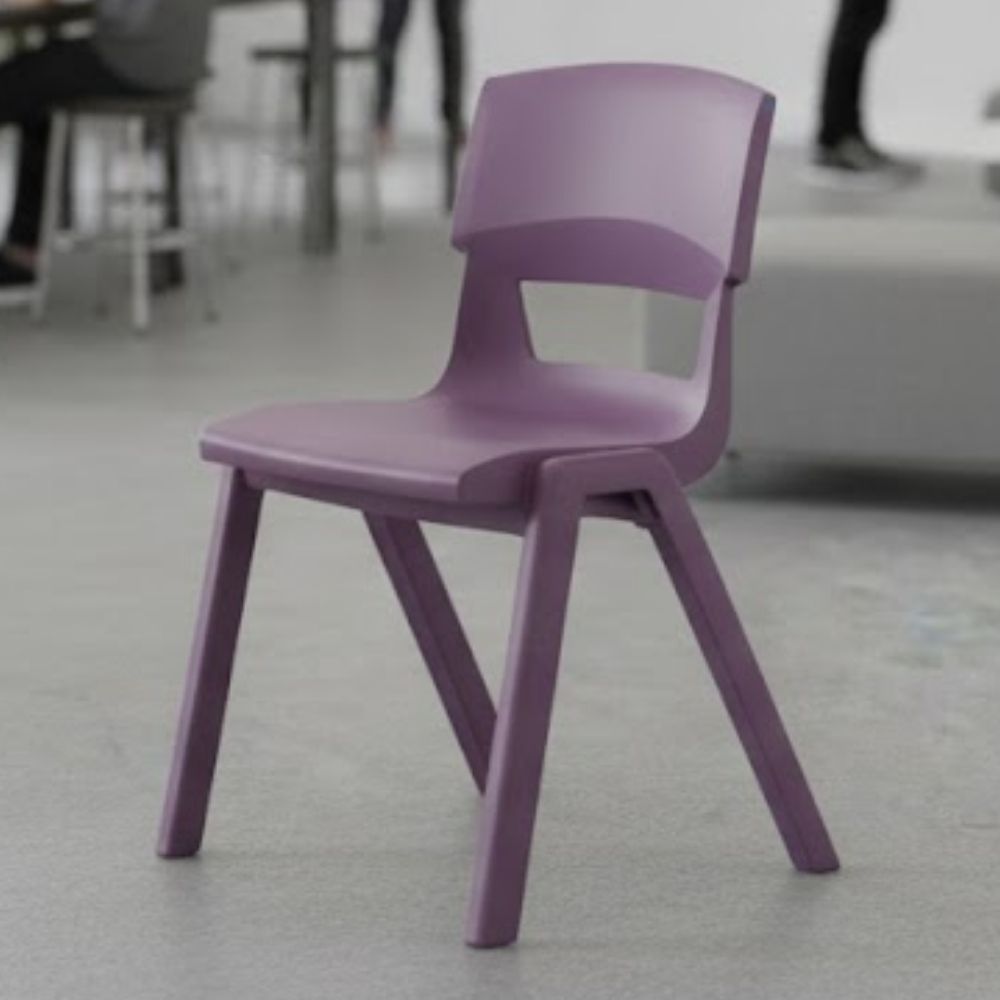 A purple plastic school chair in a classroom with a grey floor, shown with blurred students and seating in the background.