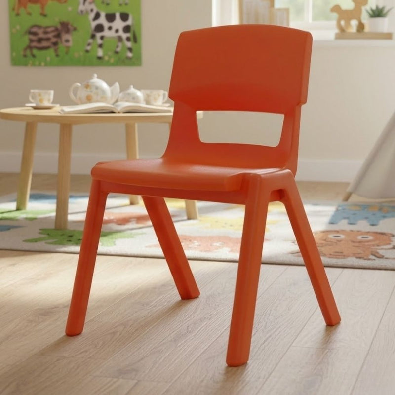 An red plastic chair in a nursery or early years room with animal wall art and a storytime table on a playful themed rug.