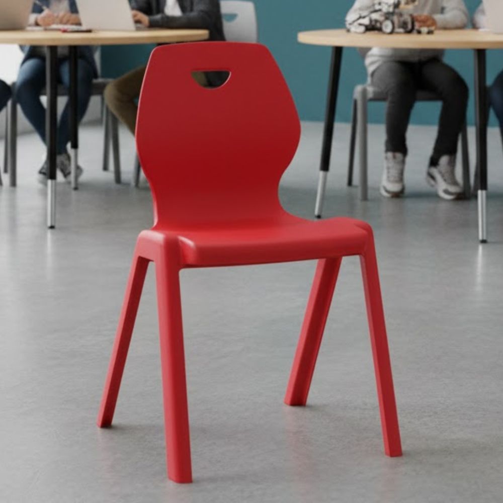 Red plastic chair with ergonomic backrest and triangular cutout, suitable for collaborative learning environments.
