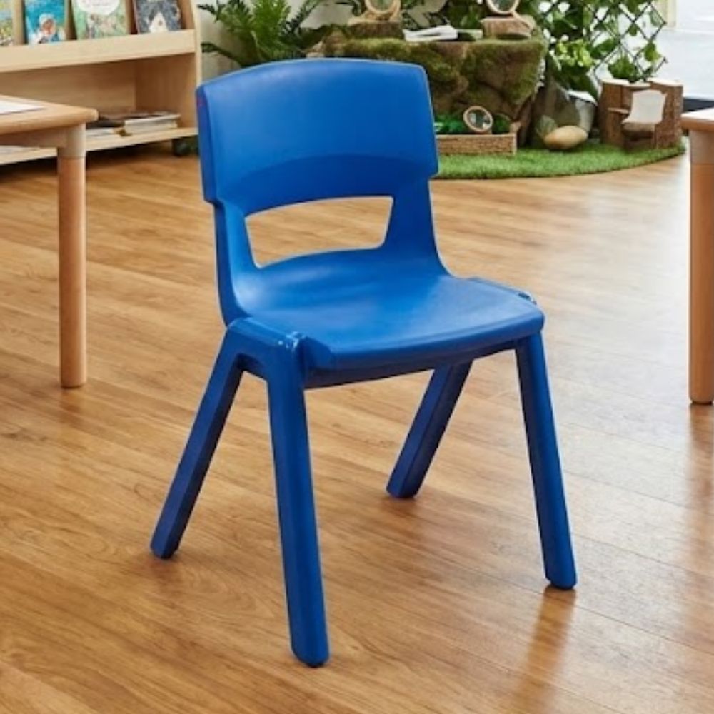 A royal blue children’s chair placed in an early years classroom featuring a nature-inspired learning zone with greenery and tactile exploration areas.