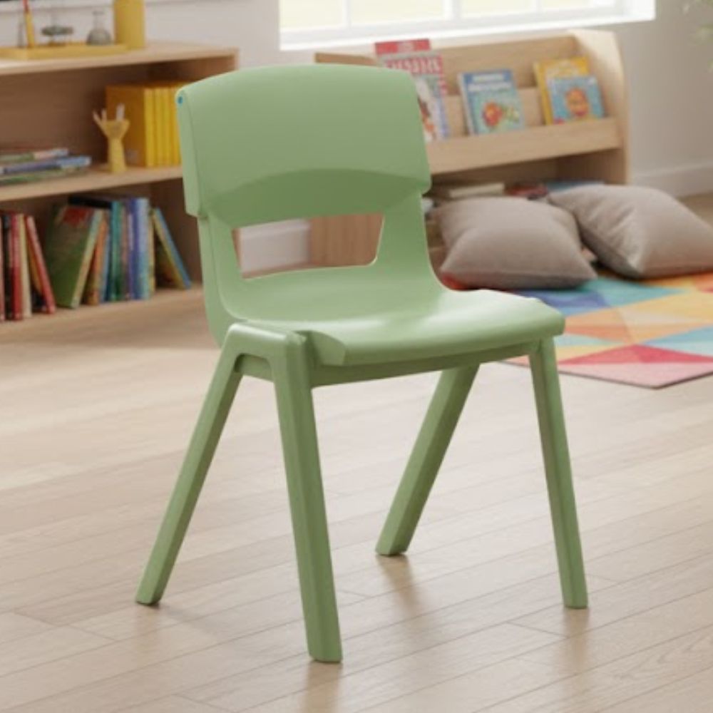 A sage green plastic chair set in a calm reading nook with bookshelves, floor cushions and geometric rugs, ideal for early literacy and group reading.