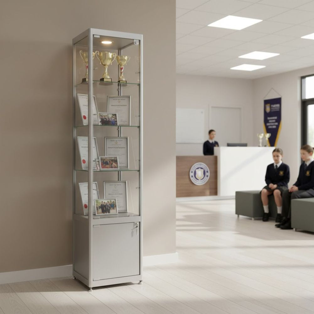 tall-glass-display-cabinet-containing-trophies-certificates-and-photos-in-a-bright-school-reception-area-with-students-waiting