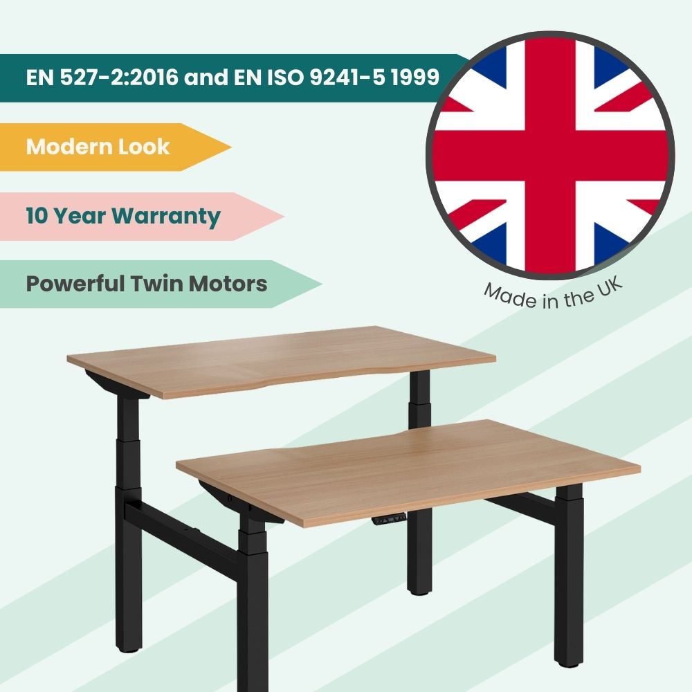Modern UK-made back-to-back electric standing desk featuring dual wood-finish tops, powerful twin motors, black frame, and 10-year warranty, compliant with EN 527-2:2016 and EN ISO 9241-5 1999 standards.
