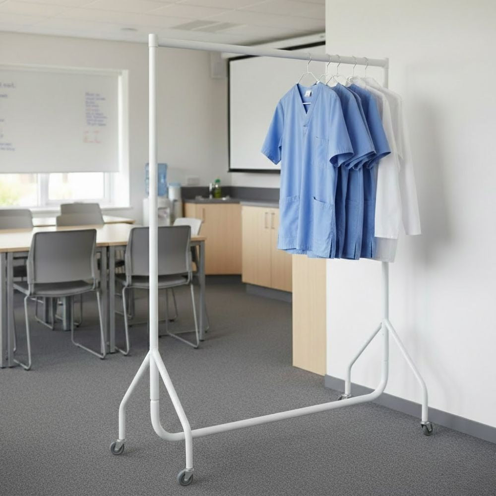 White 4ft wheeled clothes rail holding blue and white medical scrubs on hangers in a clinical training or classroom setting.