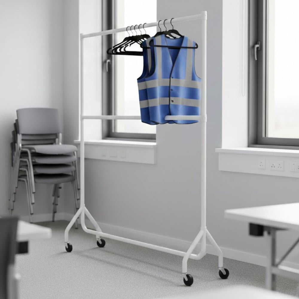 White 5ft two-tier wheeled clothes rail holding a blue high-visibility safety vest on hangers in a bright training or meeting room with stacked chairs nearby.
