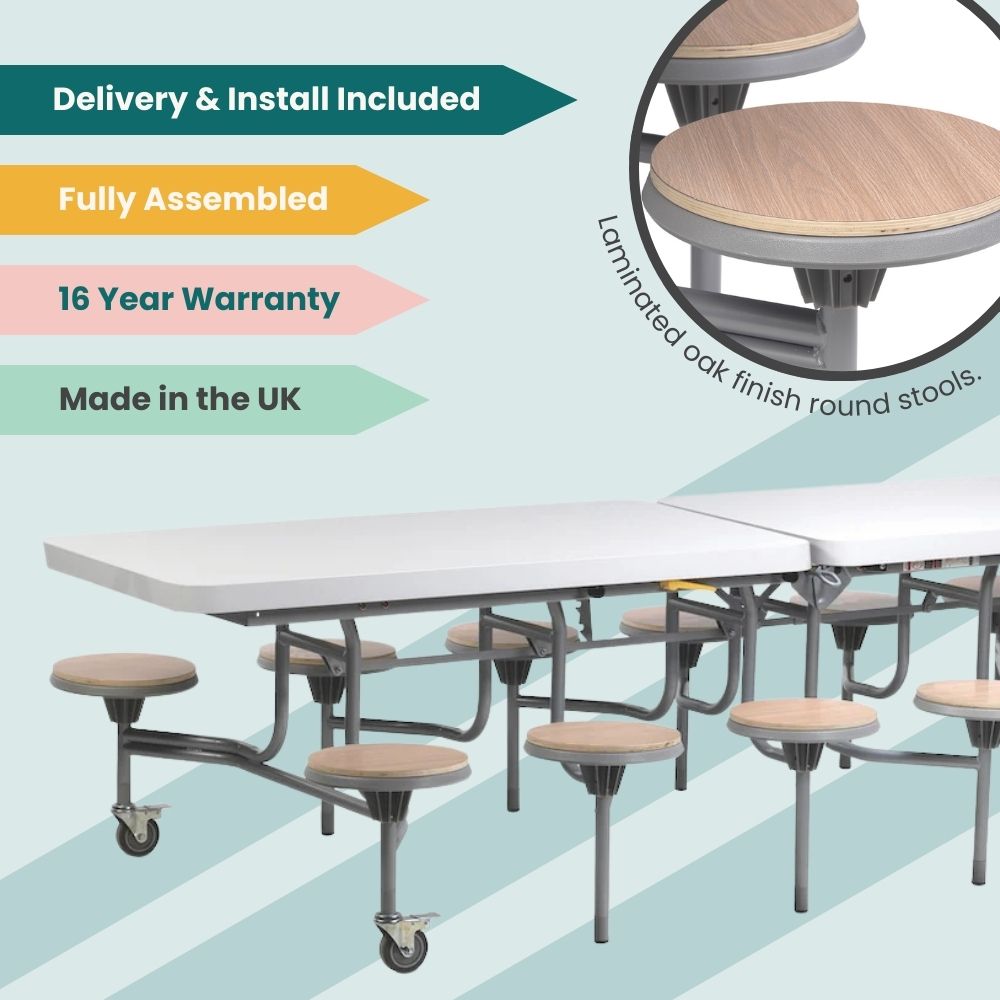 White laminate folding cafeteria table with laminated oak finish round stools and grey frame on wheels, fully assembled with delivery and installation included, 16-year warranty, and made in the UK