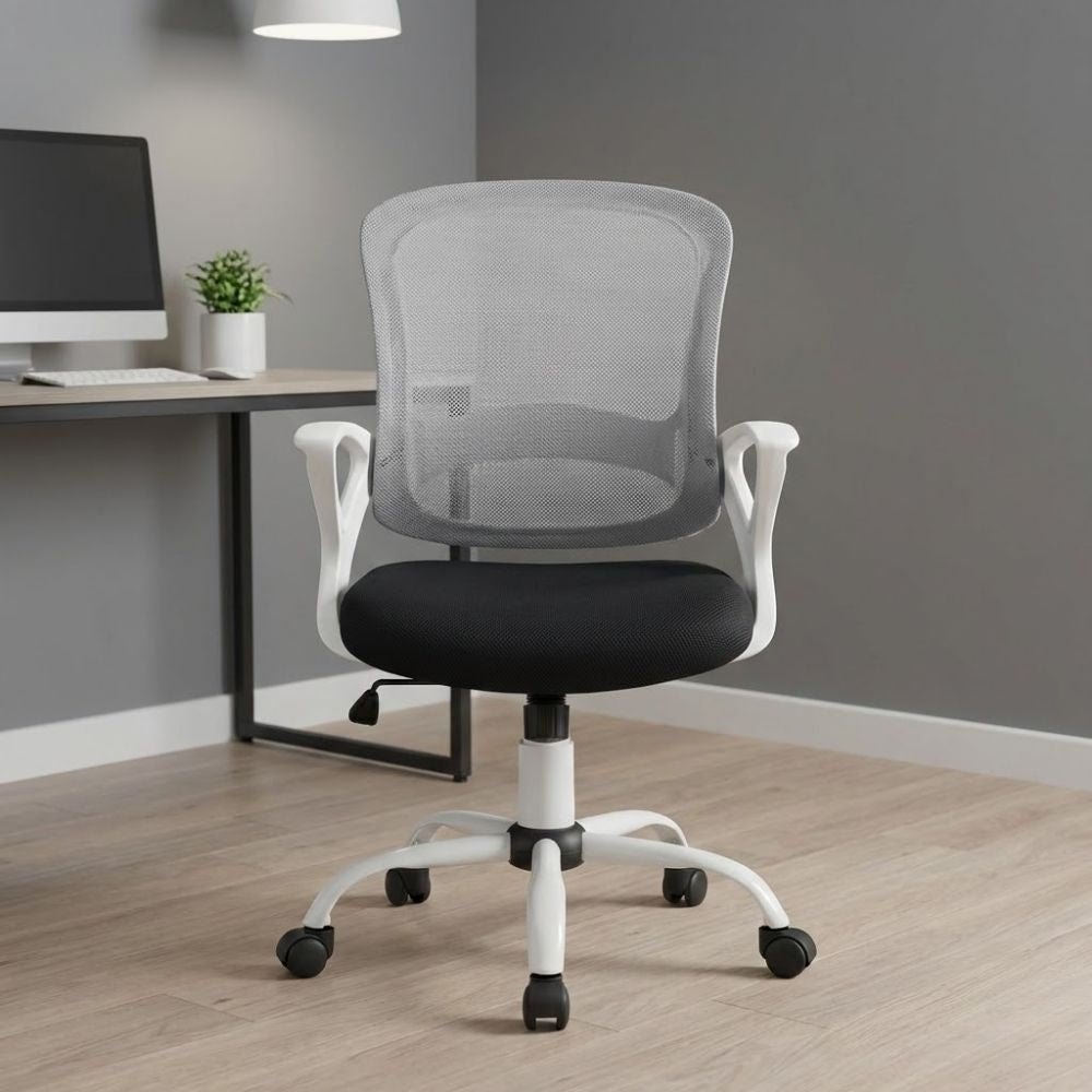 Modern white mesh back task chair with fixed arms and black cushioned seat, shown in a minimalist workspace with light wood flooring and a grey feature wall.